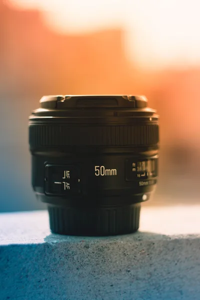50-mm-Kameraobjektiv vor warmem Hintergrund