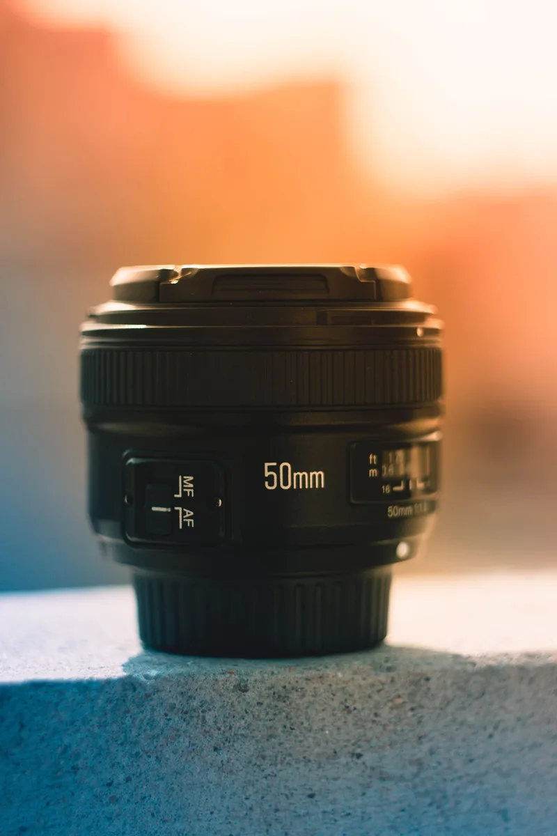 50-mm-Kameraobjektiv vor warmem Hintergrund