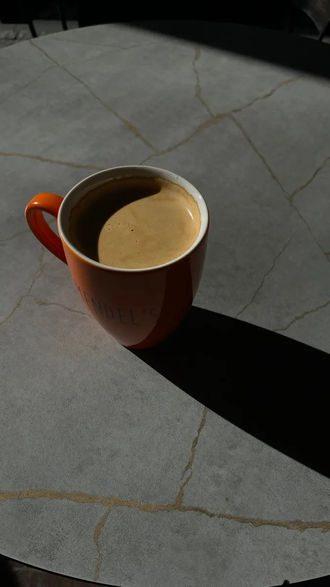 Tasse mit Schatten auf einer strukturierten Tischfläche