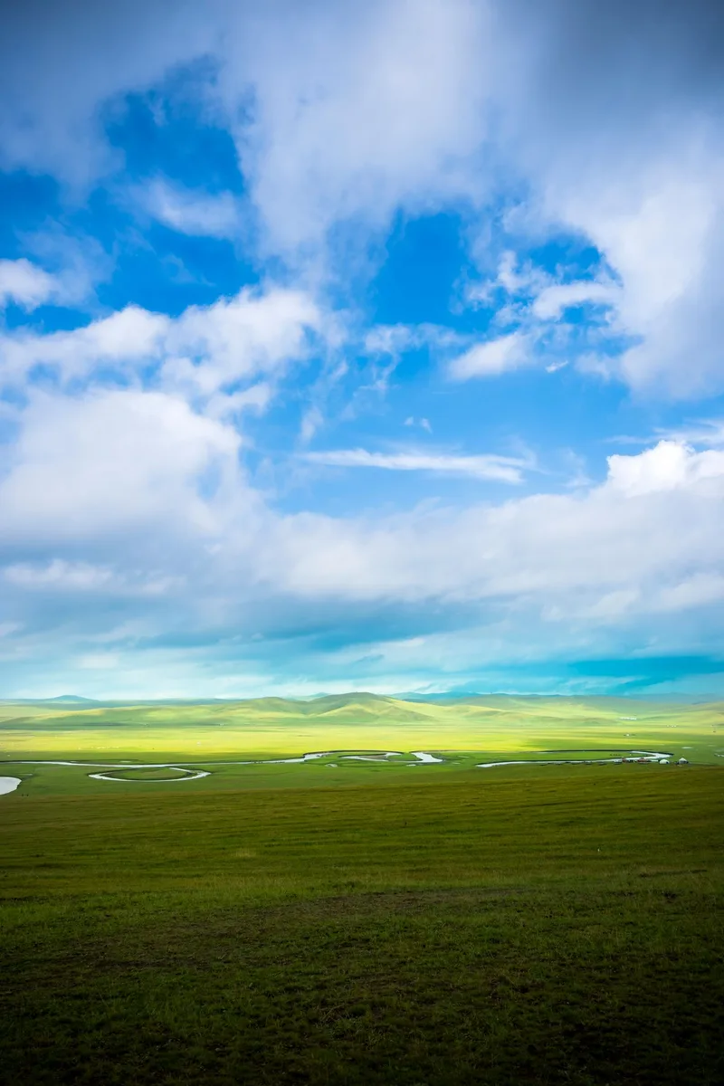 Grüne Landschaft unter einem Himmel mit Wolken