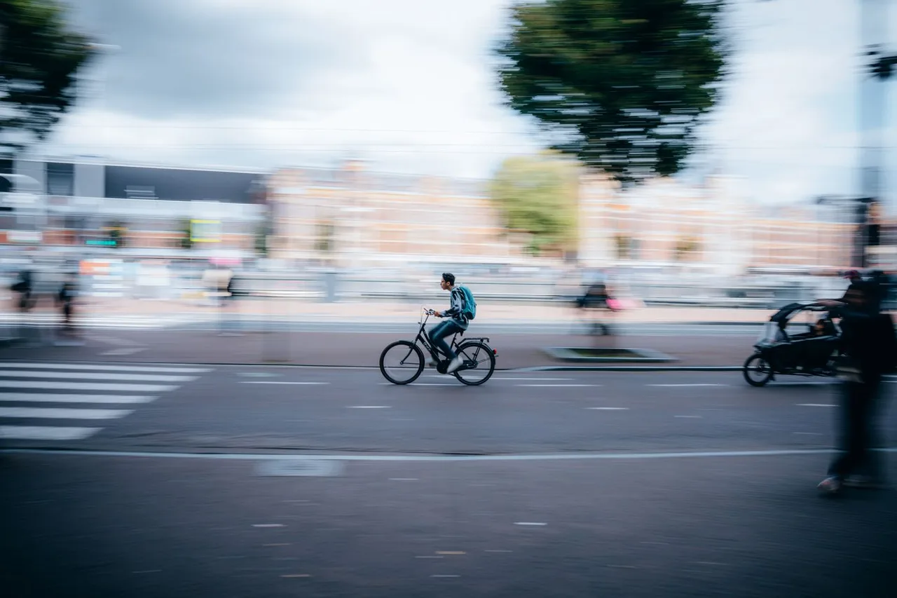 Fahrradfahrer mit sichtbarer Bewegungsunschärfe in einer Stadt
