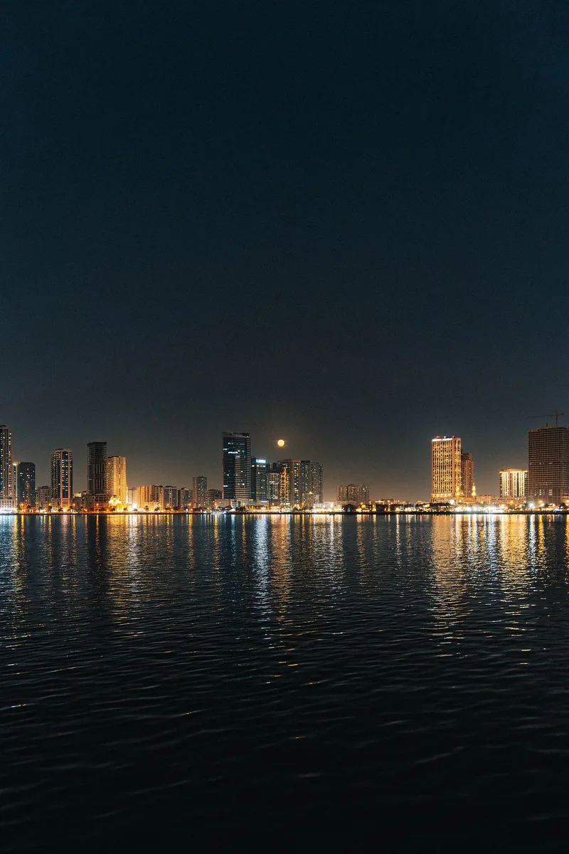 Beleuchtete Stadt mit Spiegelungen im Wasser